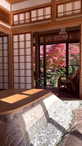 a bedroom with a bed in a room with windows at 杜の宿 らくう庵 山鹿 in Yamaga