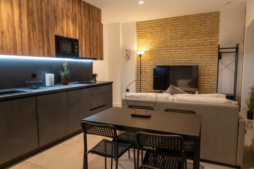 una habitación con una cama, una mesa y sillas en Apartamentos Baños, 6 CAROLA, en Linares