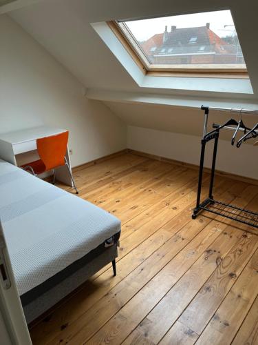 een slaapkamer met een bed, een bureau en een raam bij Demer in Aarschot