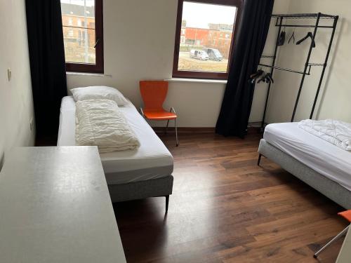 een kamer met 2 bedden, een tafel en 2 ramen bij Demer in Aarschot