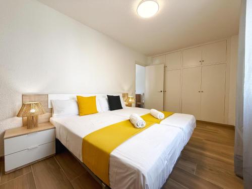 a bedroom with a large bed with yellow and white at DOMuum Holidays - DELFOS in Salou