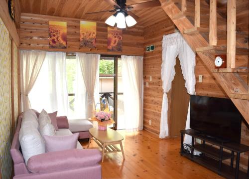 a living room with a couch and a tv at Aso Dream Villa - Vacation STAY 17297 in Okurabaru