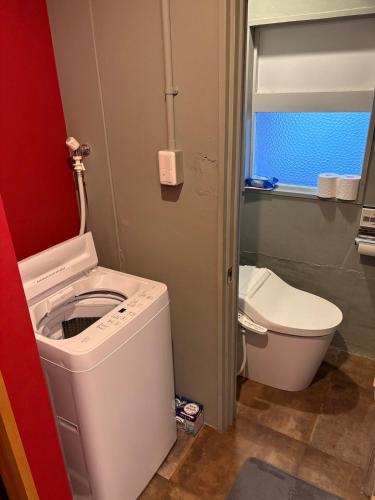 a small bathroom with a toilet and a sink at oak HOUSE in Matsuyama