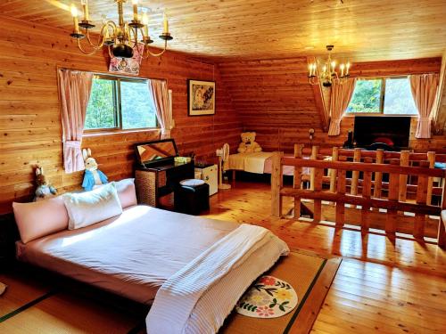 a bedroom with a large bed in a room with wooden walls at Aso Dream Villa - Vacation STAY 17297 in Okurabaru