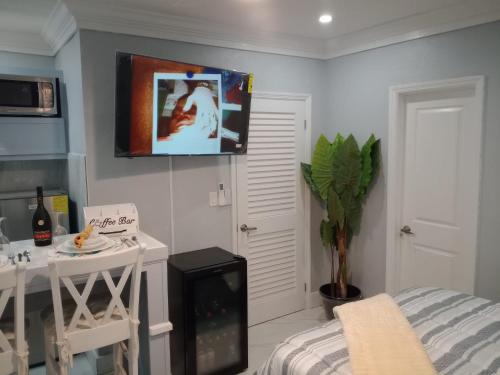 een kamer met een bed en een tafel en een tv aan de muur bij E&C short term rental in Nassau
