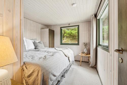 Feriehus 1140 في سوندرفيغ: غرفة نوم بها سرير ونافذة