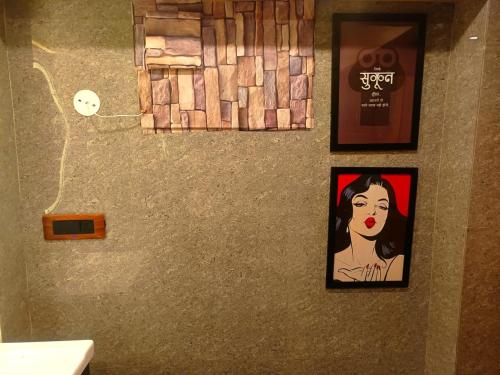 a bathroom with two pictures of a woman on the wall at Bawli Treehouse in Jibhi