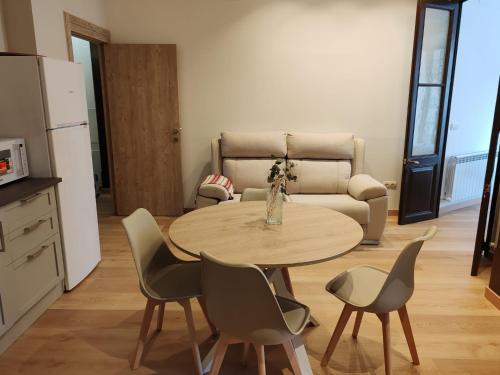 a kitchen with a table and chairs and a couch at alojamiento premium Ribadesella 2 dorm in Ribadesella