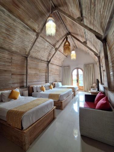 a large room with two beds and a couch at Daghan Cottage Nusa Penida in Nusa Penida