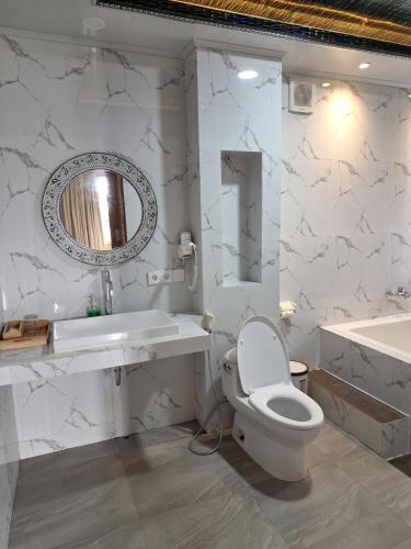 a bathroom with a toilet and a sink and a tub at Daghan Cottage Nusa Penida in Nusa Penida