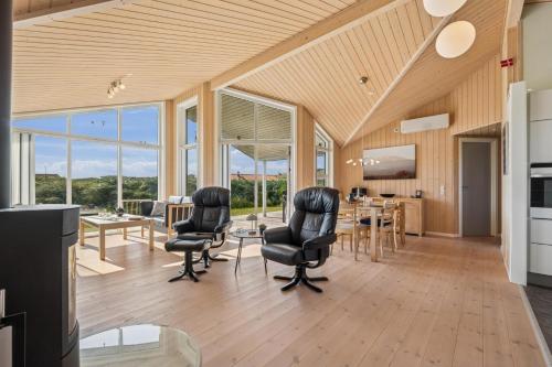Feriehus 3020 في فيد ساندي: غرفة معيشة مع كراسي وطاولة ونوافذ