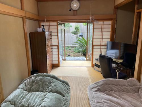 a bedroom with a bed and a sliding glass door at Iioka-classic in Asahi