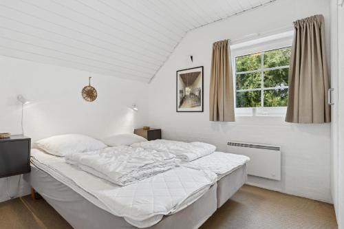 Feriehus 1145 في سوندرفيغ: غرفة نوم بيضاء مع سرير ونافذة
