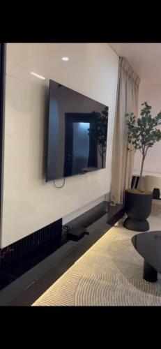 Una sala de estar con un televisor de pantalla plana en una pared. en Goldenstay apartment, en Mama