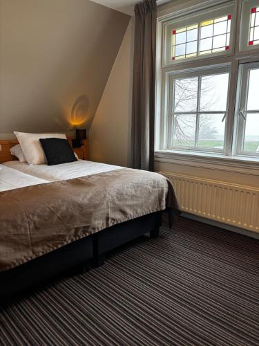 a bedroom with a bed and a large window at De Gouden Molen in Rossum