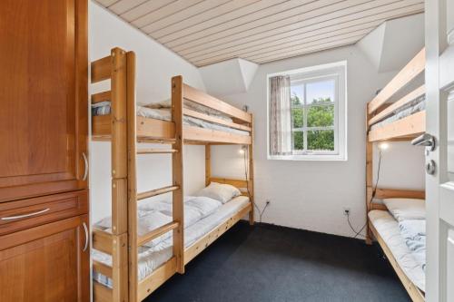 Feriehus 2020 في Øby: سريرين بطابقين في غرفة مع نافذة