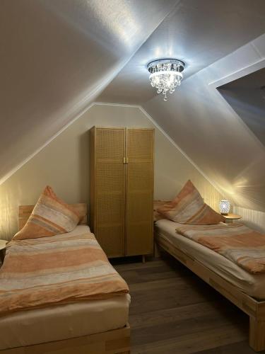 a bedroom with two beds and a chandelier at Haus Maria am Meer in Göhren