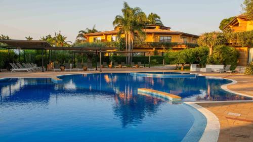 Magaggiari Hotel Resort في شينيسي: حمام سباحة كبير أمام المنزل