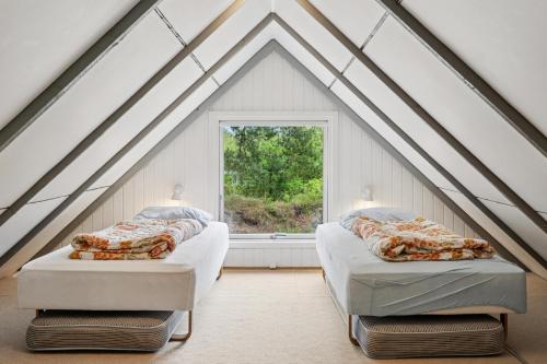two beds in a room with a window at Feriehus 1133 in Ringkøbing