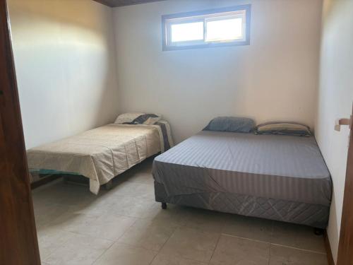 een slaapkamer met twee bedden en een raam bij CABAÑAS CAMPO y MAR in Playa Dorada
