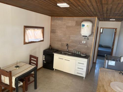 een keuken met een wastafel, een fornuis en een tafel bij CABAÑAS CAMPO y MAR in Playa Dorada