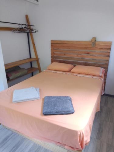 a bedroom with a large bed with two towels on it at Tiny House Potrero Cba in Potrero de Garay