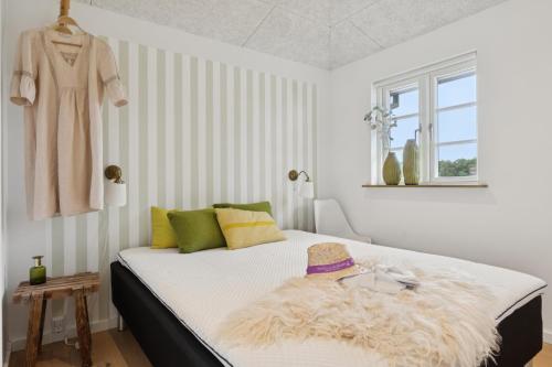 a bedroom with a bed with a hat on it at Feriehus 1142 in Ringkøbing