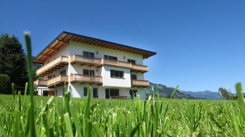 a building in the middle of a field of grass at Wiesennest in Fügenberg