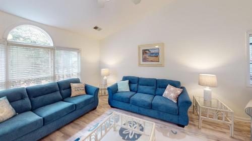 a living room with two blue couches and a table at Club Villas Unit 17D Villa in Sunset Beach
