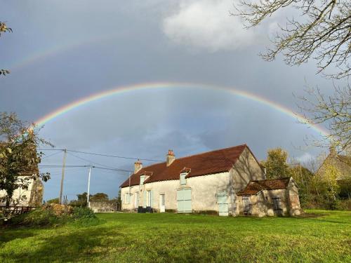 a rainbow in the sky over a house at La Maison Arc-en-ciel in Brigueuil-le-Chantre