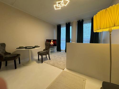 a living room with a table and chairs and a tv at I&A Residence - Roseni tn in Tallinn