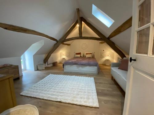 a attic bedroom with a bed and a couch at La Maison Arc-en-ciel in Brigueuil-le-Chantre