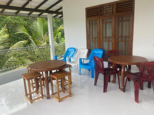 a group of tables and chairs on a porch at Sedasi Holiday Home in Tangalle