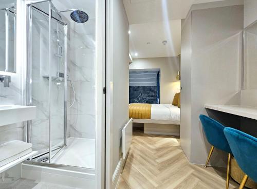 een kleine badkamer met een douche en een slaapkamer bij Hotel London in Londen