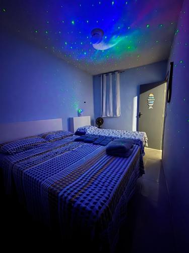 a bedroom with two beds and a ceiling with stars at Refúgio Pérola Capixaba in Marataizes