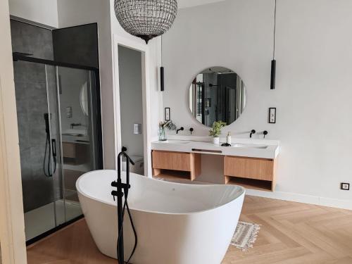 a white bathroom with two sinks and a tub at alojamiento Premium Ribadesella Vistas al Mar in Ribadesella