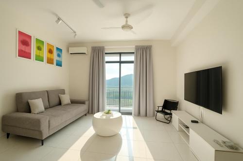 a living room with a couch and a tv at The Sun Executive Suite - Dolphin's Home in Bayan Lepas