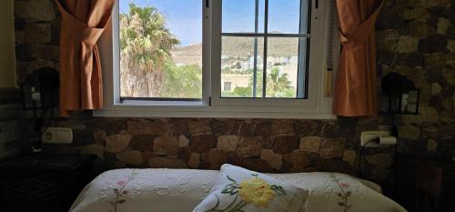 a bedroom with a bed and a window with a view at Apartamentos Wily y Mavi in San José