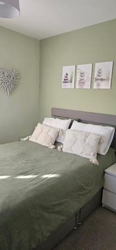 a bedroom with a large bed with white pillows at Hart's Place in Leicester