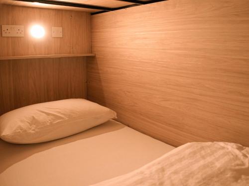 Habitación pequeña con cama y pared de madera. en Gardiner House Hostel, en Dublín