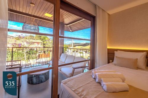 ムクジェーにあるFique em apartamento 2 quartos no centro de Mucugêのベッドとバルコニーのある寝室