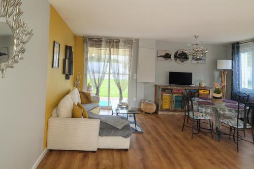 un salon avec un canapé et une table dans l'établissement Maison Chardonnerets - Poitiers, à Biard