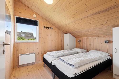 Feriehus 1143 في Nørby: غرفة نوم بسريرين في غرفة خشبية