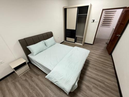 a small bedroom with a bed and a mirror at Hatasan Homestay Guess House in Perai