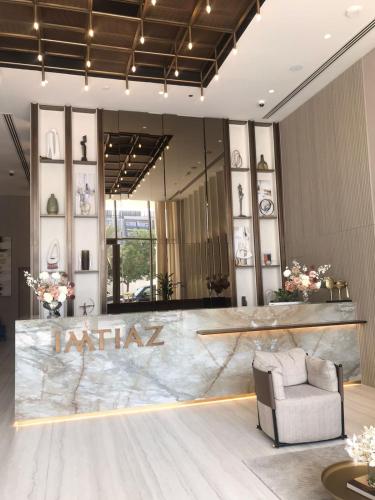 a lobby with a waiting area with a chair and a mirror at Luxury Furnished Studio with Alexa Automation JVC in Dubai