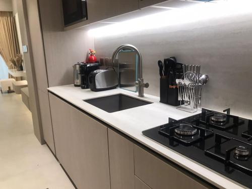 a kitchen counter with a sink and a stove at Luxury Furnished Studio with Alexa Automation JVC in Dubai