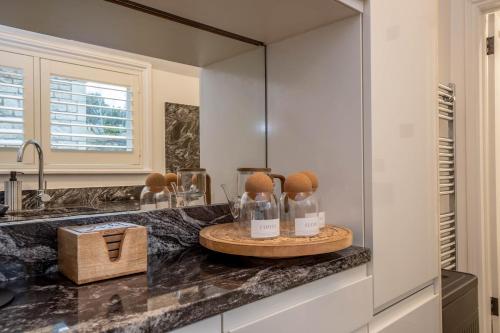 - une salle de bains pourvue d'un comptoir avec des bouteilles dans l'établissement Stunning One Bed - Central Witney, à Eynsham