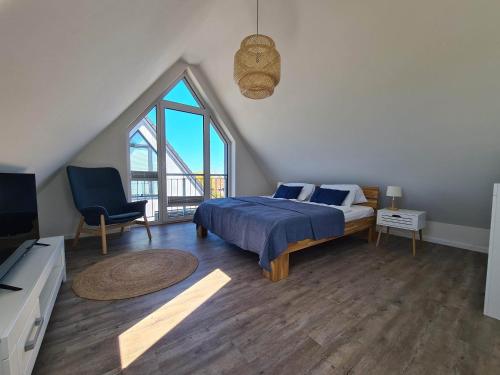 a bedroom with a bed and a large window at Deichkoje in Westerdeichstrich