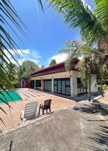 a house with a chair and a swimming pool at Share pool 1 room 2 bedroom in Ao Nang 