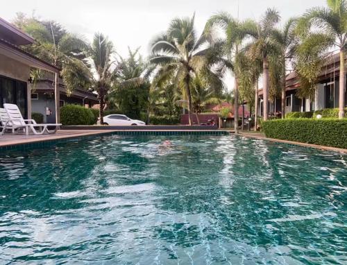 a swimming pool with turquoise water and palm trees at Share pool 1 room 2 bedroom in Ao Nang 